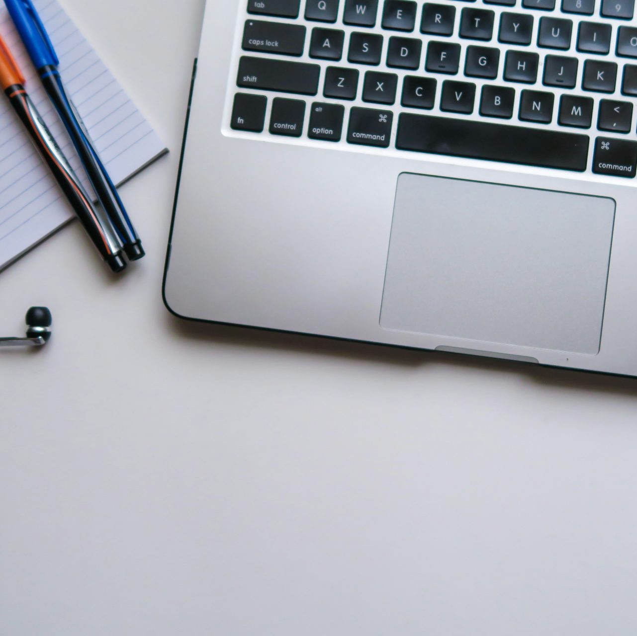 silver laptop computer beside white ruled paper